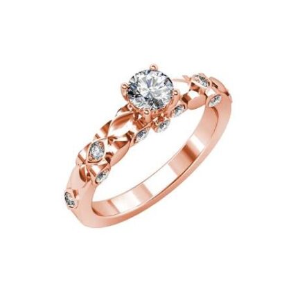 rose-gold ring with a central round-cut clear gemstone, surrounded by smaller stones and an intricate, openwork band. Short product description A romantic rose-gold ring featuring a brilliant center stone and delicate pavé detailing. Its intricate band adds an elegant, contemporary touch, making it a graceful choice for engagements, special occasions, or everyday luxury. Alt text Rose-gold ring with a round center stone and intricate band decorated with smaller gemstones.